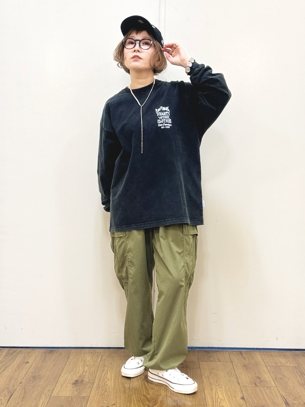 ブラック系のTシャツ/カットソー、ブラック系のバックパック/リュック、ホワイト系のスニーカーを着用したレディースの秋コーディネートの3枚目の写真