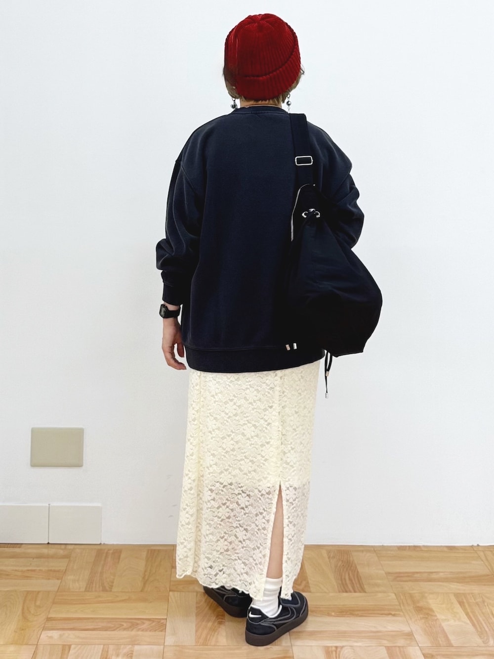 ホワイト系のスカート、ブラック系のスニーカー、ブラック系のショルダーバッグを着用したレディースの秋コーディネートの6枚目の写真