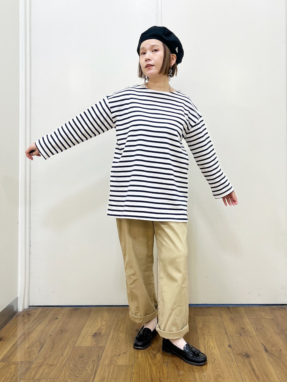ベージュ系のチノパンツ、ブラック系のベスト、ブルー系のTシャツ/カットソーを着用したレディースの冬コーディネートの5枚目の写真
