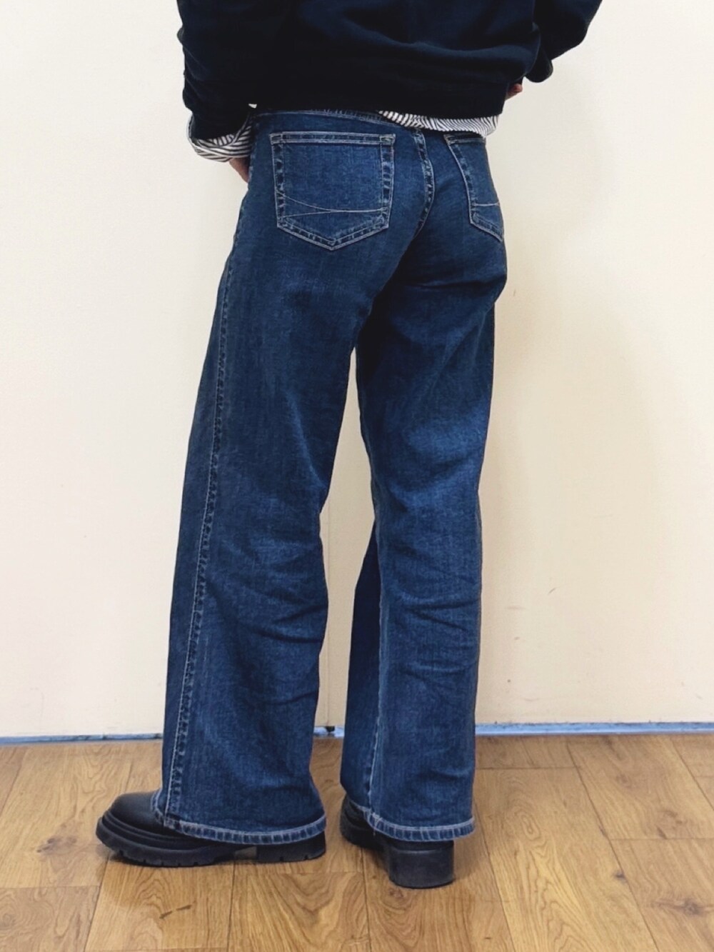 ブルー系のキャミソール、ブルー系のデニムパンツ、ブラック系のブーツを着用したレディースの冬コーディネートの8枚目の写真