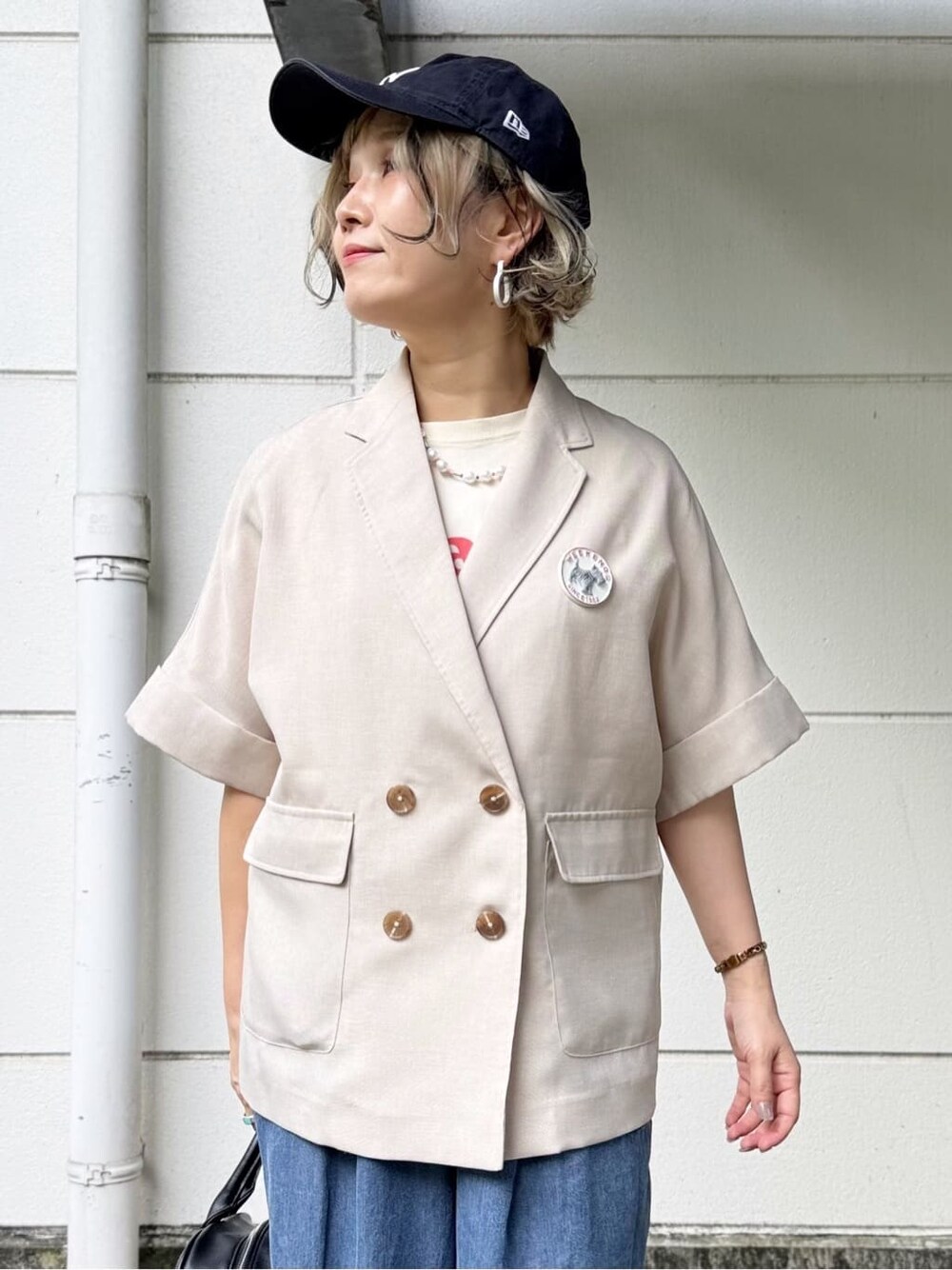 ベージュ系のテーラードジャケット、ブルー系のデニムパンツ、ホワイト系のTシャツ/カットソーを着用したレディースの春コーディネートの2枚目の写真