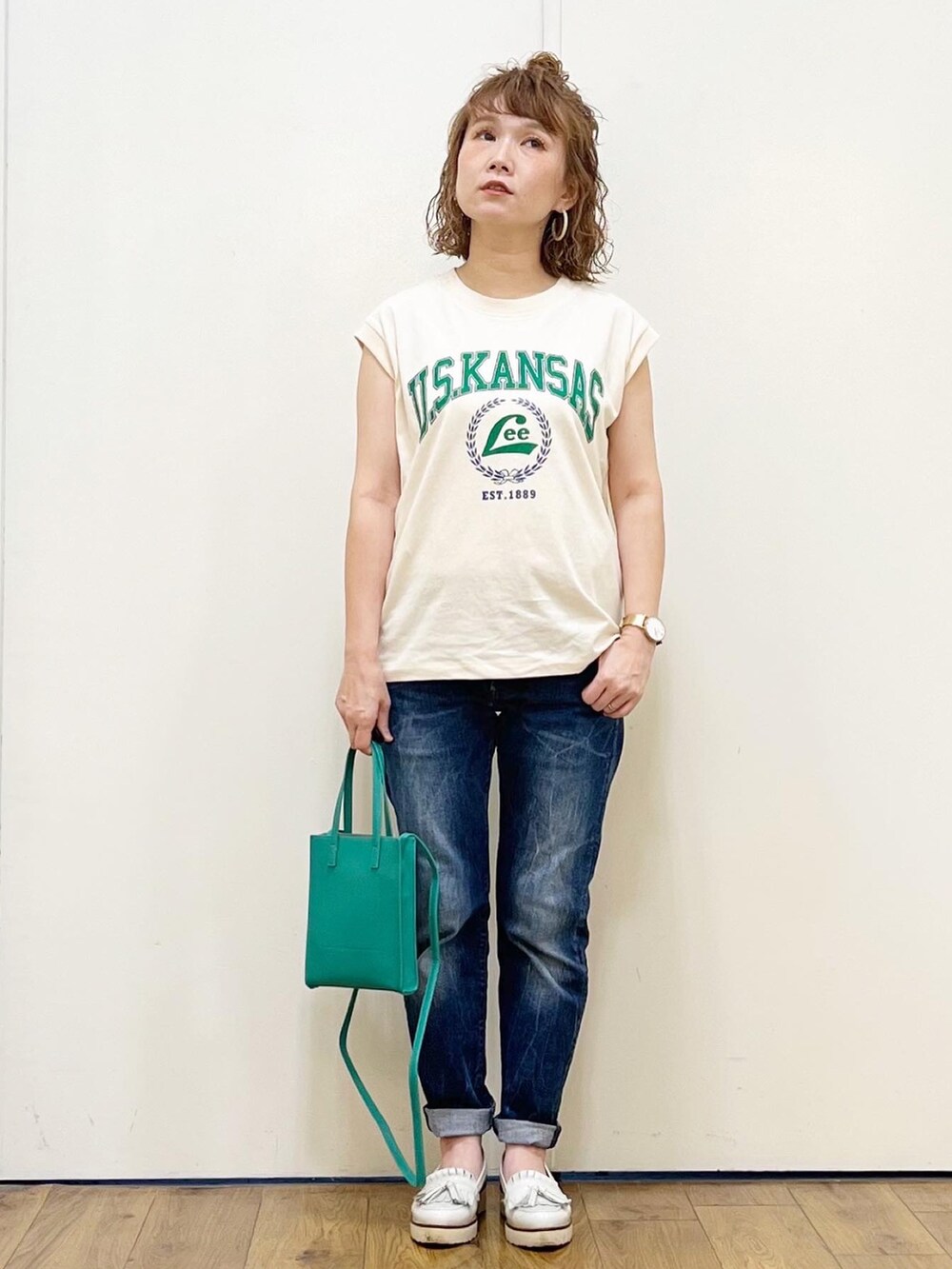 ホワイト系のTシャツ/カットソー、ブルー系のデニムパンツ、ホワイト系のローファーを着用したレディースの夏コーディネートの3枚目の写真