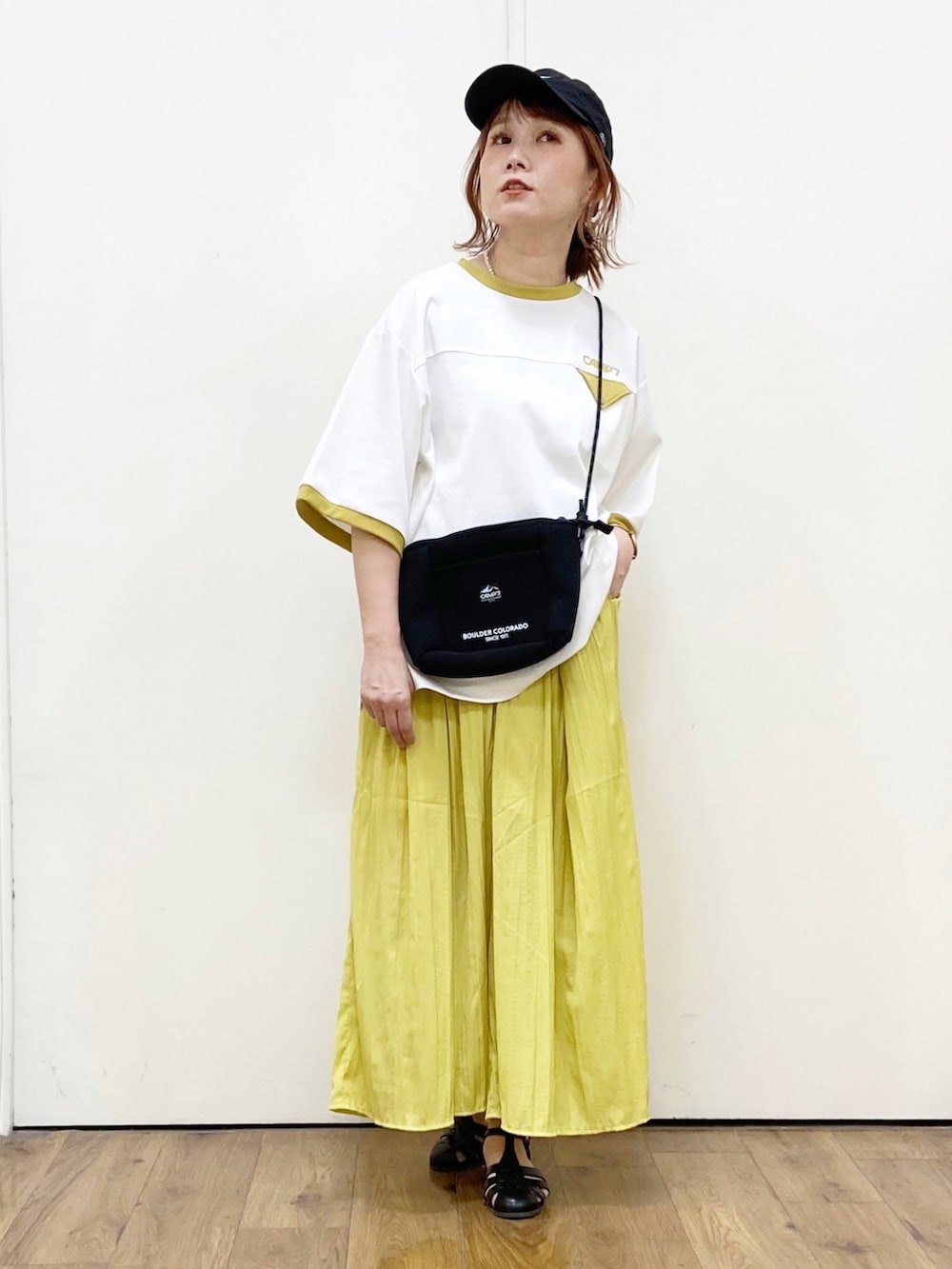 ホワイト系のTシャツ/カットソー、イエロー系のその他パンツ、ブラック系のショルダーバッグを着用したレディースの夏コーディネートの2枚目の写真