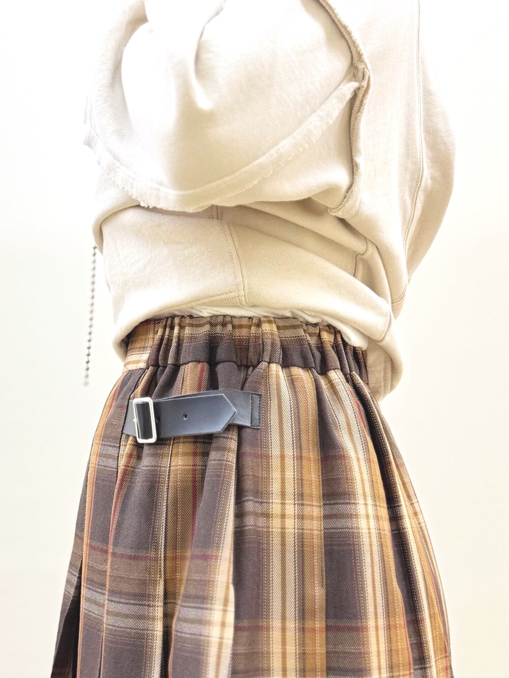 ベージュ系のスウェット、イエロー系のスカート、イエロー系のショルダーバッグを着用したレディースの秋コーディネートの9枚目の写真