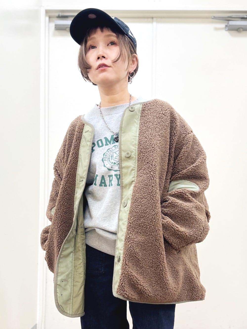 ブラック系のブーツ、ブルー系のデニムパンツ、グリーン系のブルゾンを着用したレディースの秋コーディネートの5枚目の写真