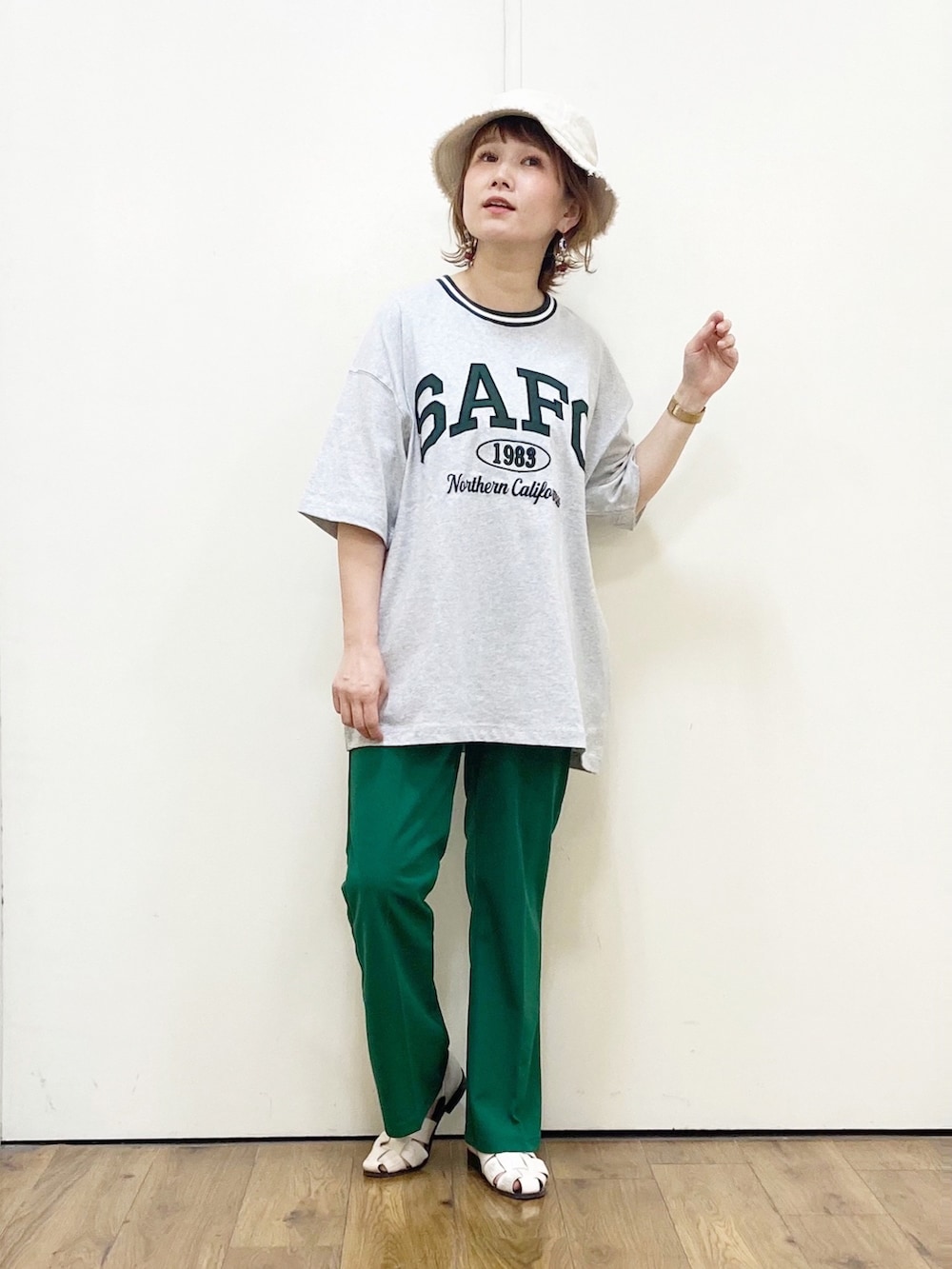 グレー系のTシャツ/カットソー、グリーン系のパンツ、ホワイト系のサンダルを着用したレディースの春コーディネートの2枚目の写真