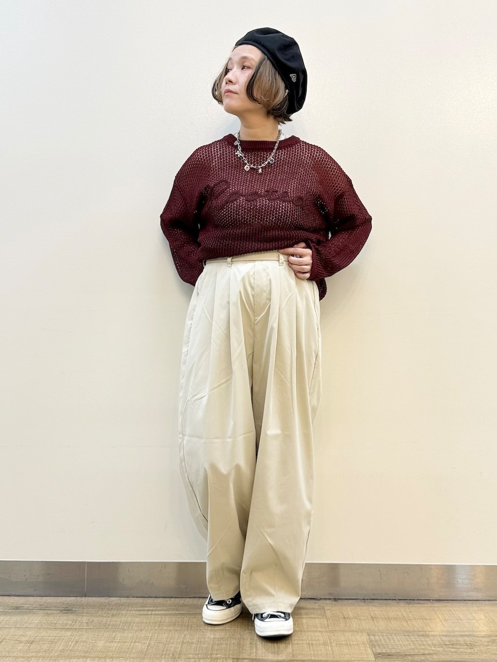 レッド系のニット/セーター、グレー系のその他パンツ、ブラック系のショルダーバッグを着用したレディースの秋コーディネートの7枚目の写真