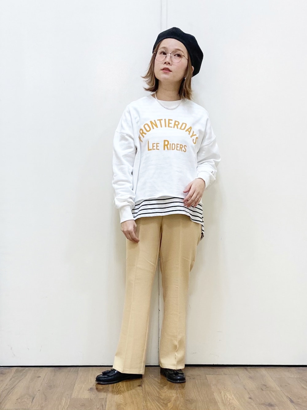 グレー系のショルダーバッグ、ホワイト系のスウェット、ホワイト系のTシャツ/カットソーを着用したレディースの冬コーディネートの2枚目の写真