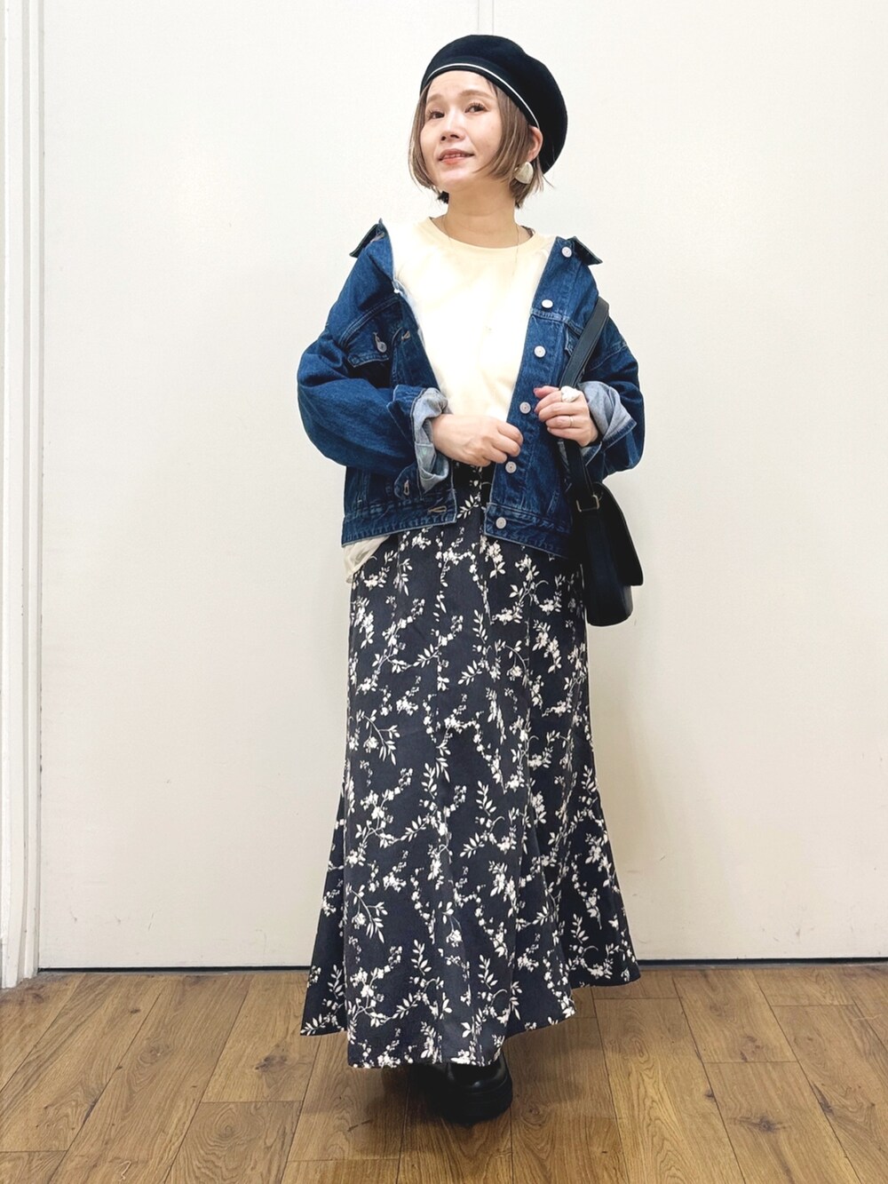 ブルー系のデニムジャケット、ブラック系のスカート、ブラック系のショルダーバッグを着用したレディースの秋コーディネートの6枚目の写真