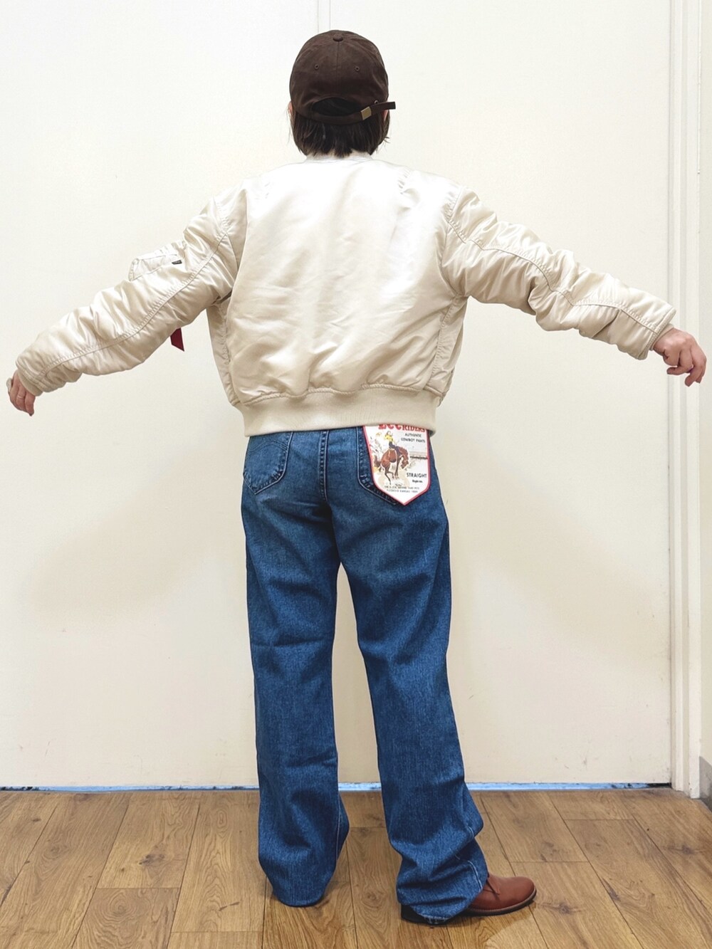 ホワイト系のMA-1、ブルー系のデニムパンツ、ブラウン系のアンサンブルを着用したレディースの秋コーディネートの5枚目の写真