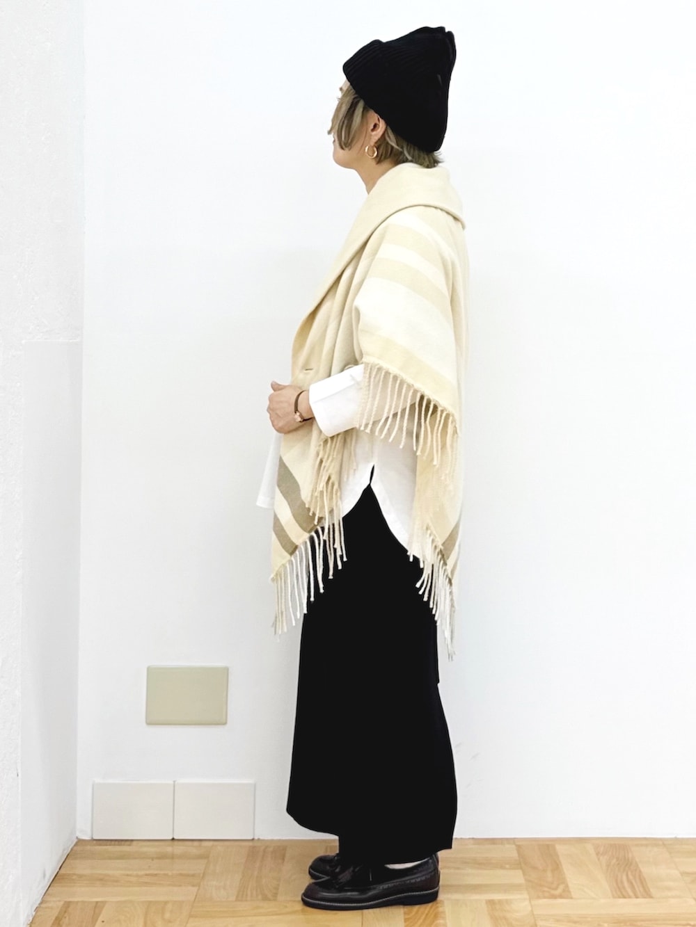 ブラック系のスカート、ホワイト系のTシャツ/カットソー、ブラック系のニットキャップ/ビーニーを着用したレディースの秋コーディネートの4枚目の写真