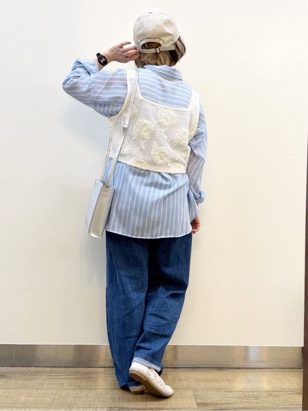 ブルー系のシャツ/ブラウス、ホワイト系のベスト、ブルー系のデニムパンツを着用したレディースの春コーディネートの5枚目の写真
