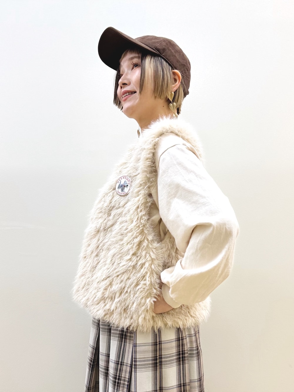 ベージュ系のベスト、ベージュ系のTシャツ/カットソー、ベージュ系のスカートを着用したレディースの秋コーディネートの4枚目の写真