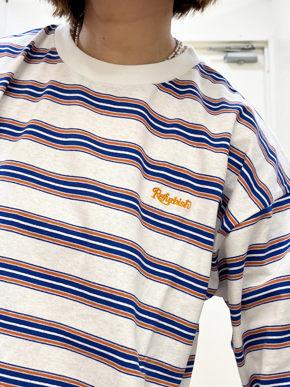 ブルー系のデニムパンツ、オレンジ系のパーカー、ホワイト系のTシャツ/カットソーを着用したレディースの冬コーディネートの5枚目の写真