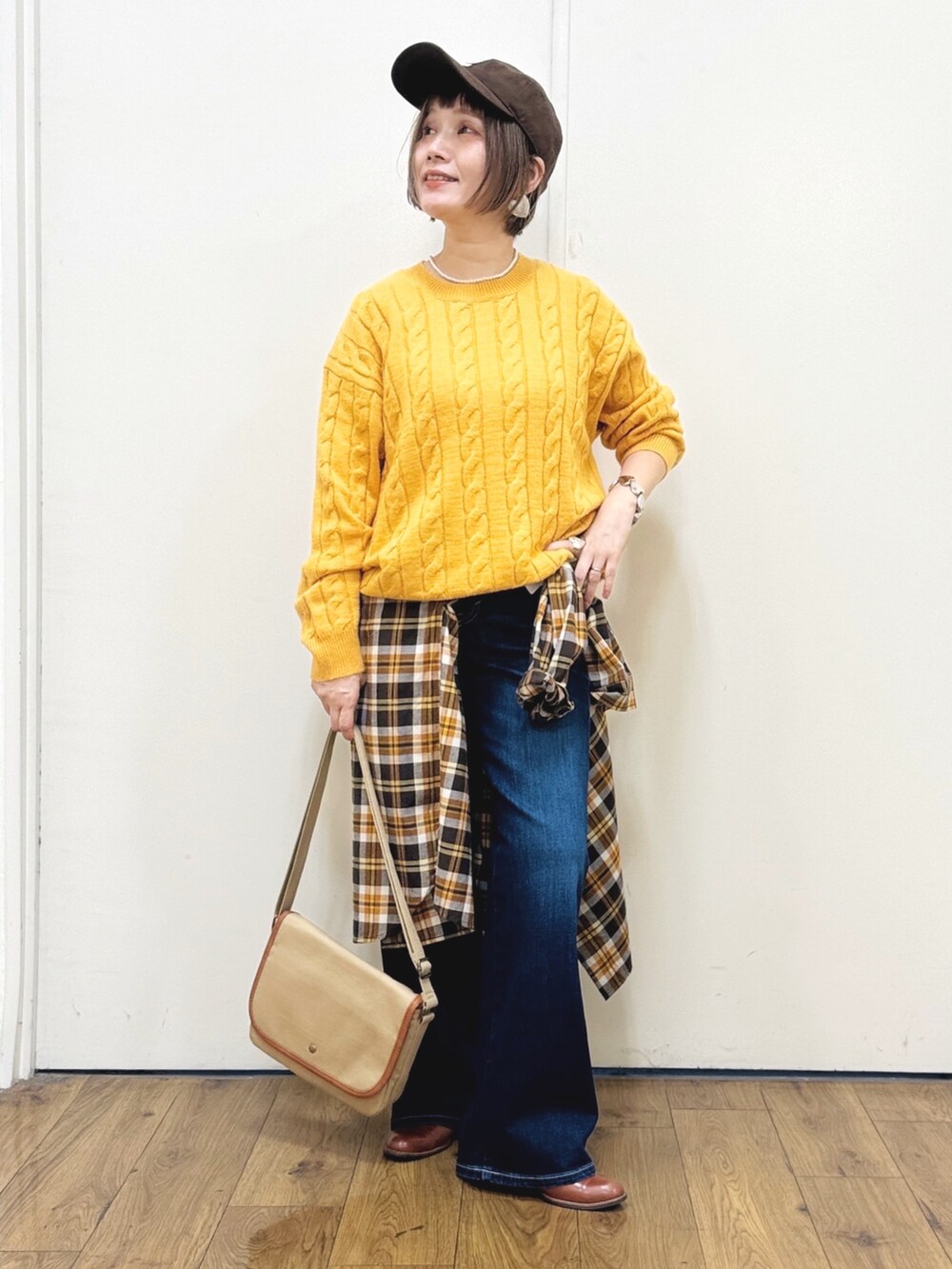 ブラウン系のドレスシューズ、ブルー系のデニムパンツ、イエロー系のニット/セーターを着用したレディースの秋コーディネートの3枚目の写真