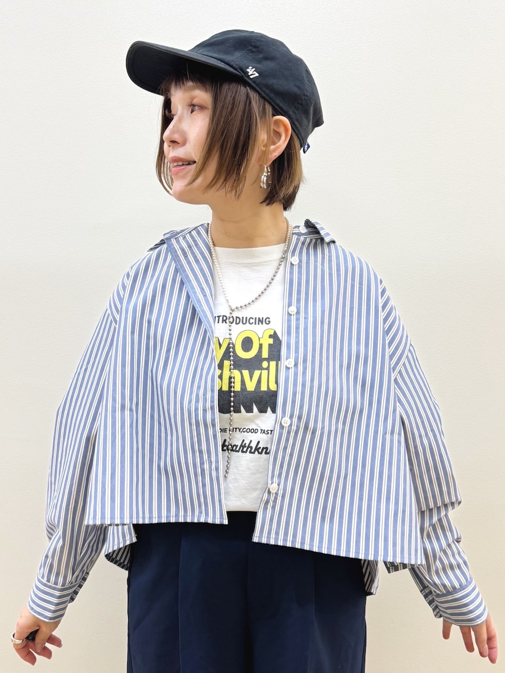 ホワイト系のショルダーバッグ、ブラウン系のドレスシューズ、ブルー系のその他パンツを着用したレディースの秋コーディネートの2枚目の写真