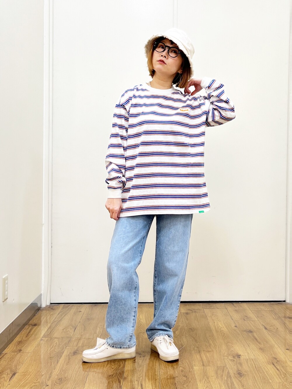 ブルー系のデニムパンツ、オレンジ系のパーカー、ホワイト系のTシャツ/カットソーを着用したレディースの冬コーディネートの4枚目の写真