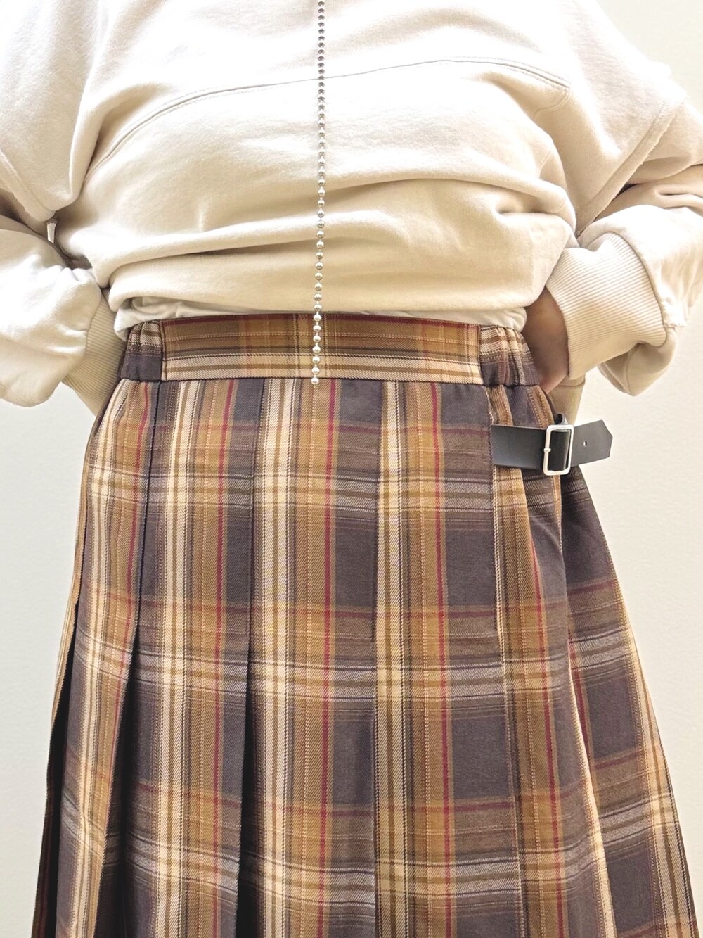 ベージュ系のスウェット、イエロー系のスカート、イエロー系のショルダーバッグを着用したレディースの秋コーディネートの8枚目の写真