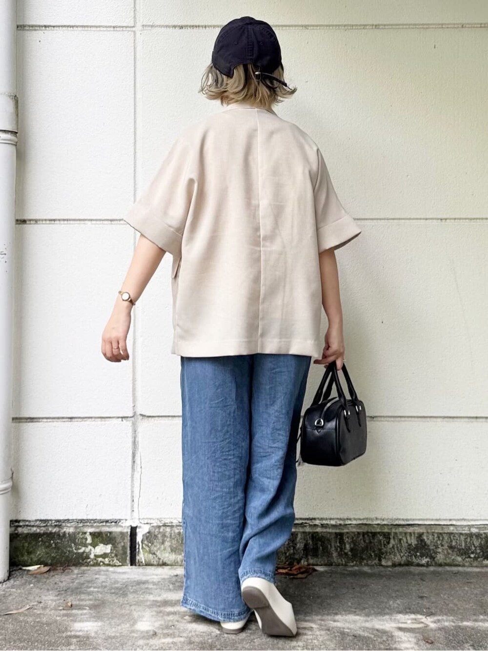 ベージュ系のテーラードジャケット、ブルー系のデニムパンツ、ホワイト系のTシャツ/カットソーを着用したレディースの春コーディネートの4枚目の写真