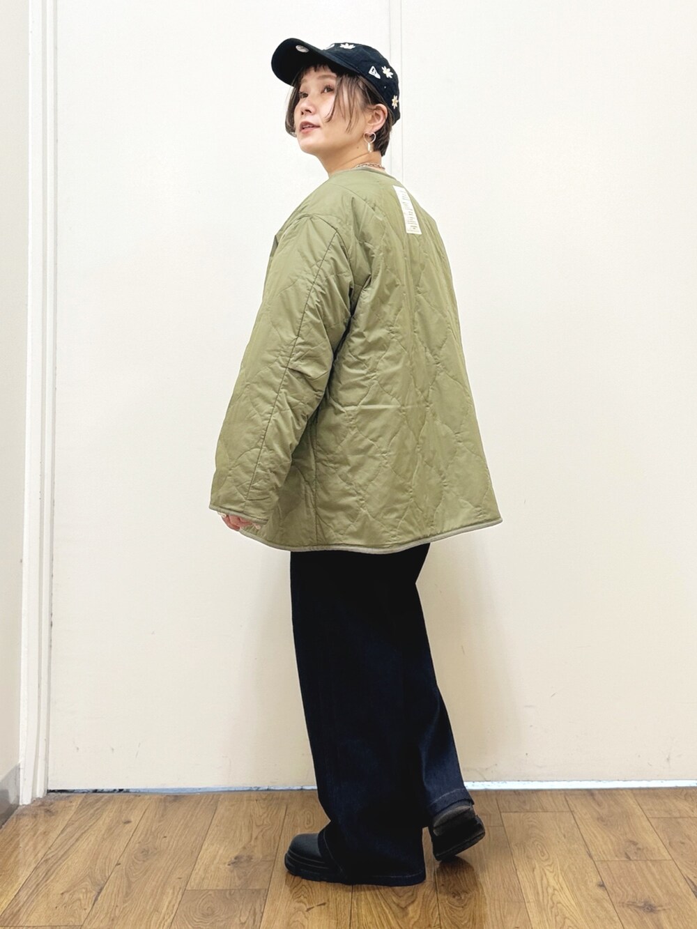 ブラック系のブーツ、ブルー系のデニムパンツ、グリーン系のブルゾンを着用したレディースの秋コーディネートの3枚目の写真