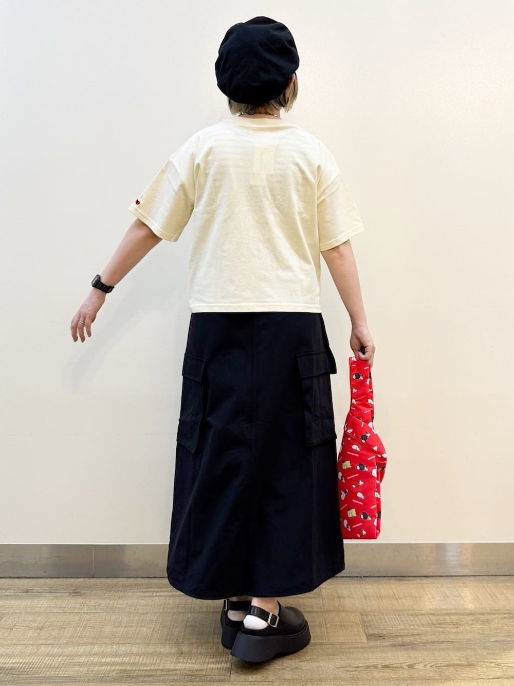 ホワイト系のTシャツ/カットソー、ブラック系のスカート、レッド系のエコバッグ/サブバッグを着用したレディースの春コーディネートの7枚目の写真