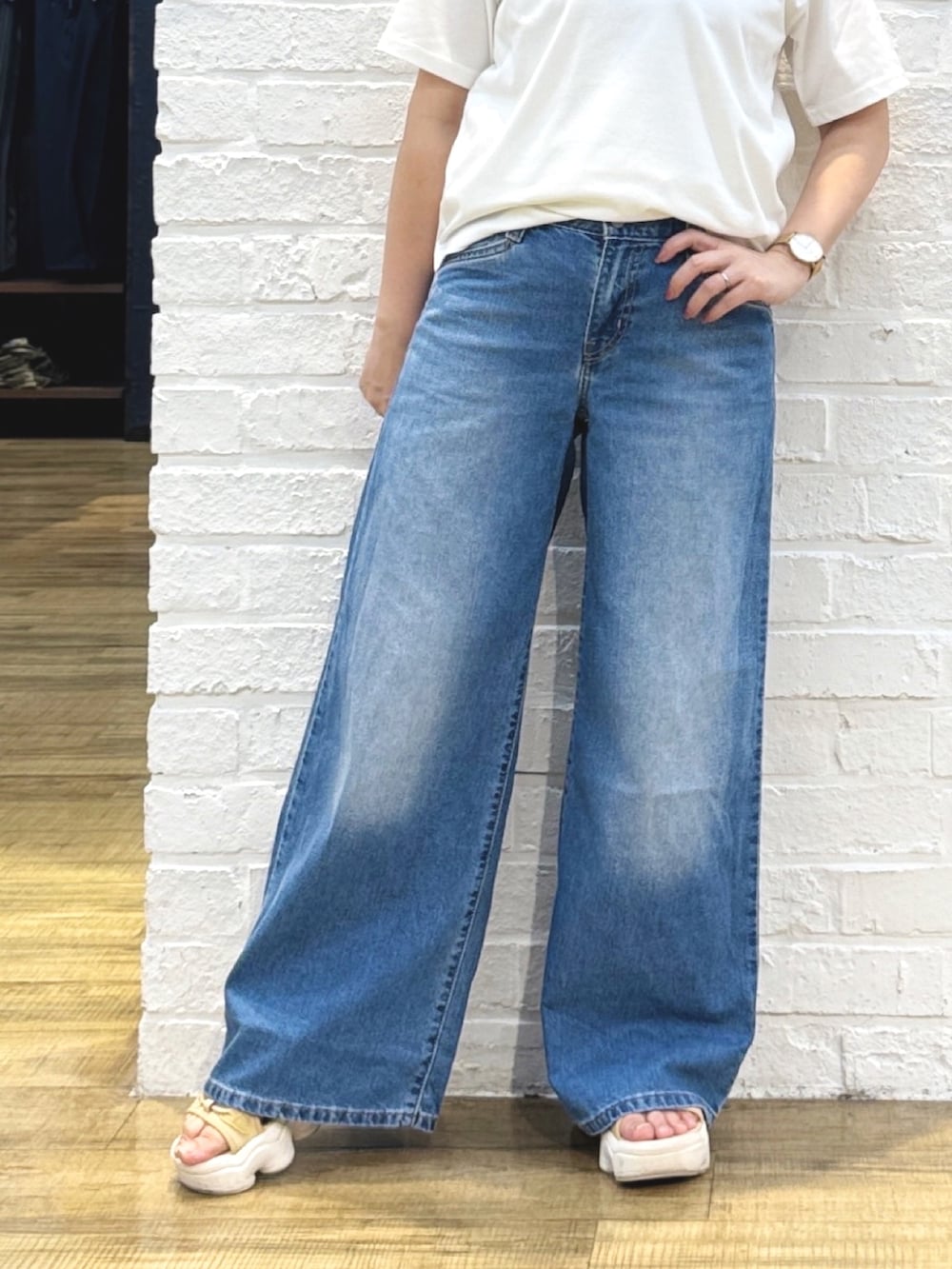 ホワイト系のTシャツ/カットソー、ブルー系のデニムパンツ、ゴールド系のハンドバッグを着用したレディースの夏コーディネートの8枚目の写真