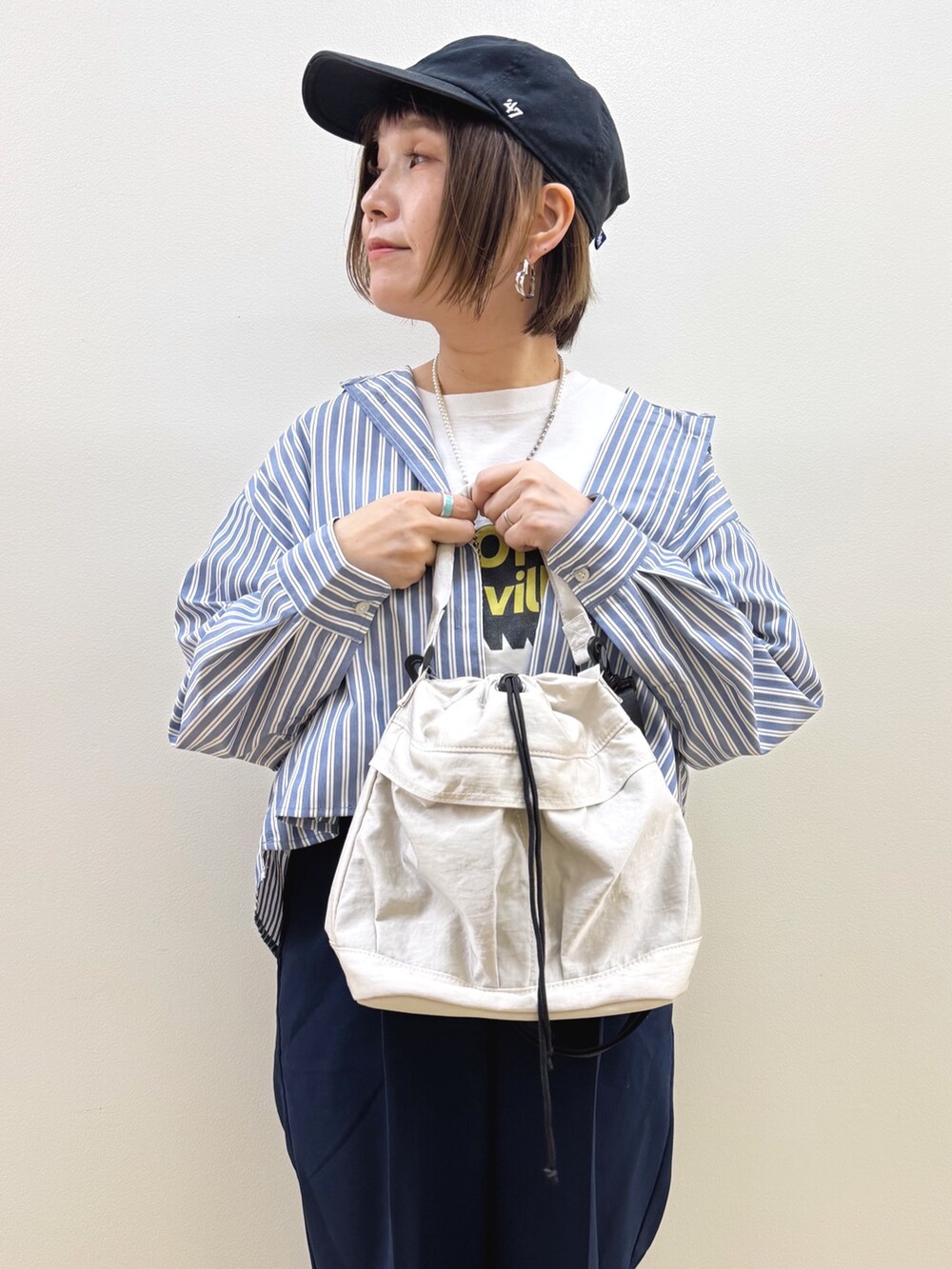 ホワイト系のショルダーバッグ、ブラウン系のドレスシューズ、ブルー系のその他パンツを着用したレディースの秋コーディネートの9枚目の写真