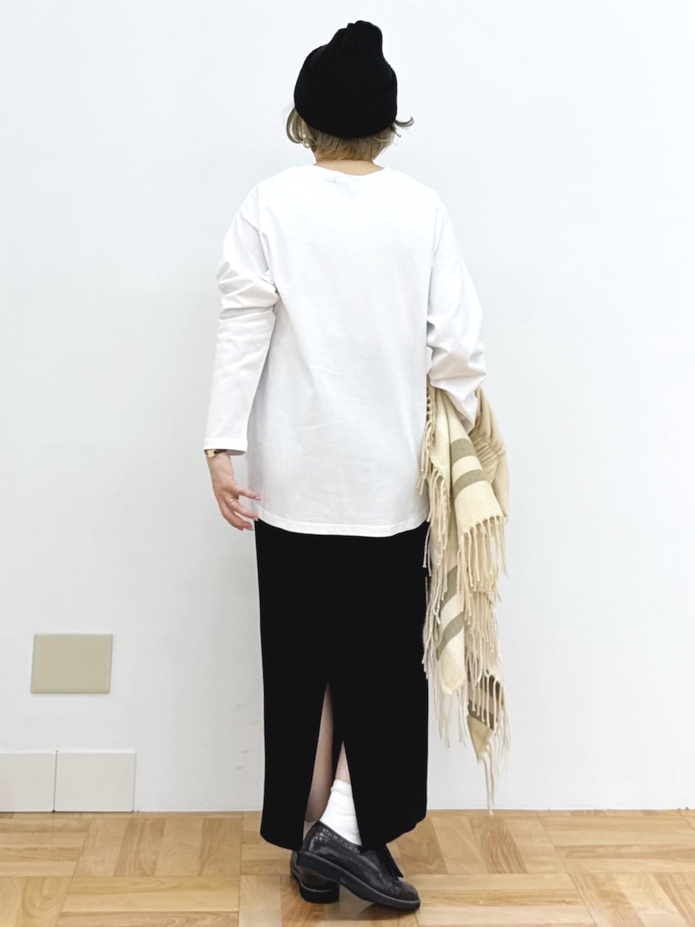 ブラック系のスカート、ホワイト系のTシャツ/カットソー、ブラック系のニットキャップ/ビーニーを着用したレディースの秋コーディネートの10枚目の写真