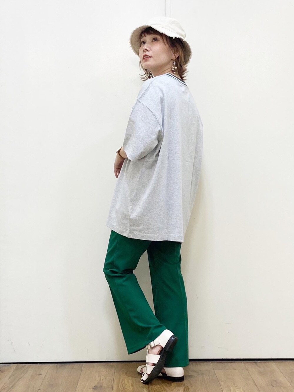 グレー系のTシャツ/カットソー、グリーン系のパンツ、ホワイト系のサンダルを着用したレディースの春コーディネートの3枚目の写真