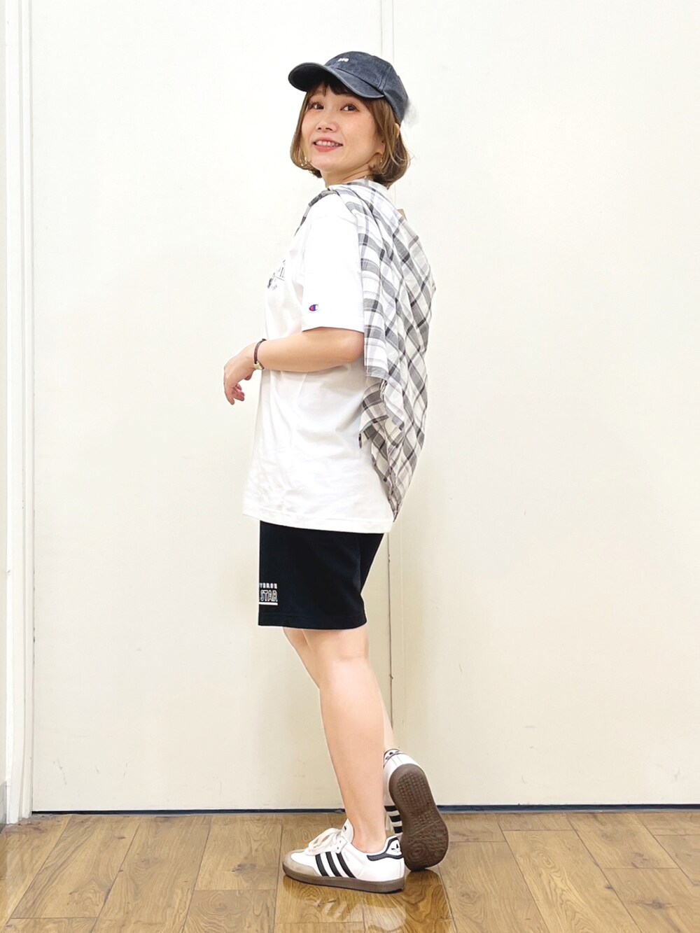 ブラック系のスウェットパンツ、オレンジ系のトートバッグ、ホワイト系のTシャツ/カットソーを着用したレディースの夏コーディネートの2枚目の写真