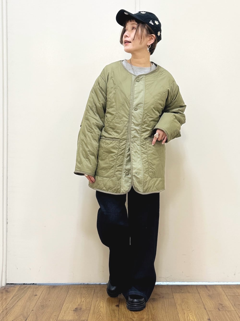 ブラック系のブーツ、ブルー系のデニムパンツ、グリーン系のブルゾンを着用したレディースの秋コーディネートの2枚目の写真