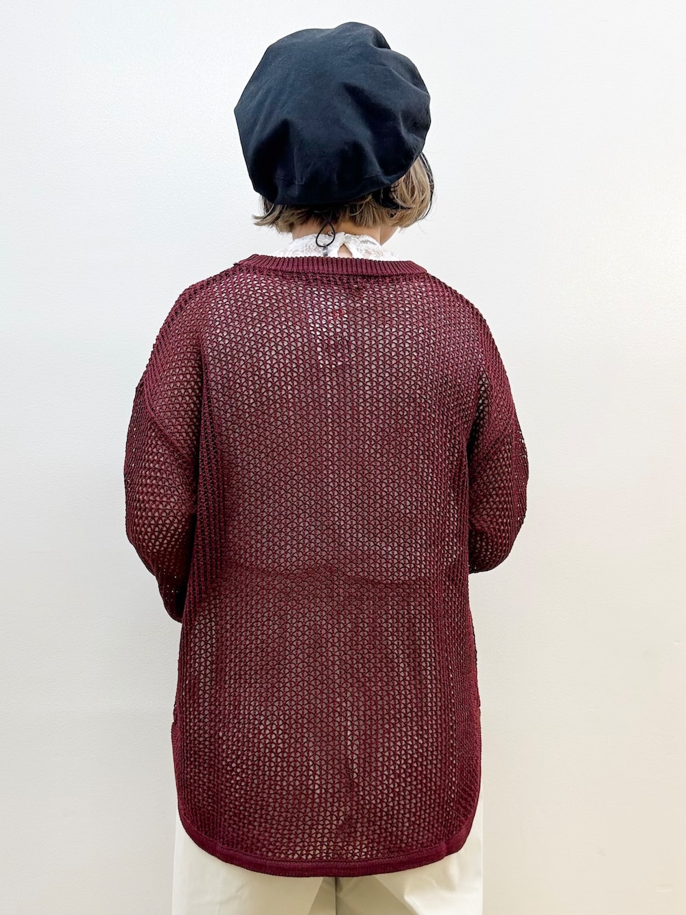 レッド系のニット/セーター、グレー系のその他パンツ、ブラック系のショルダーバッグを着用したレディースの秋コーディネートの6枚目の写真