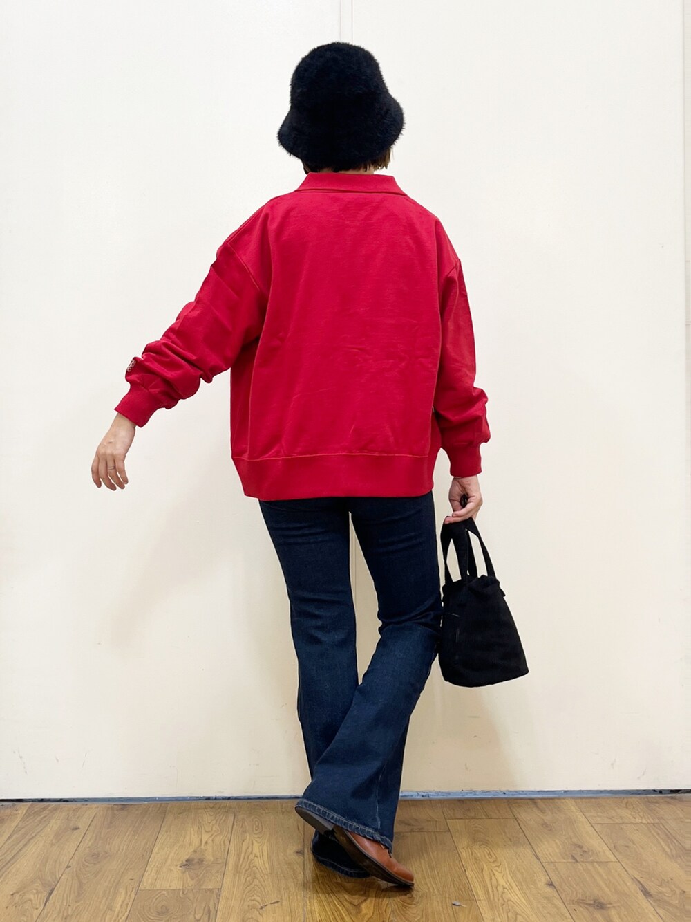 ブラック系のショルダーバッグ、ブルー系のデニムパンツ、レッド系のカーディガン/ボレロを着用したレディースの秋コーディネートの4枚目の写真