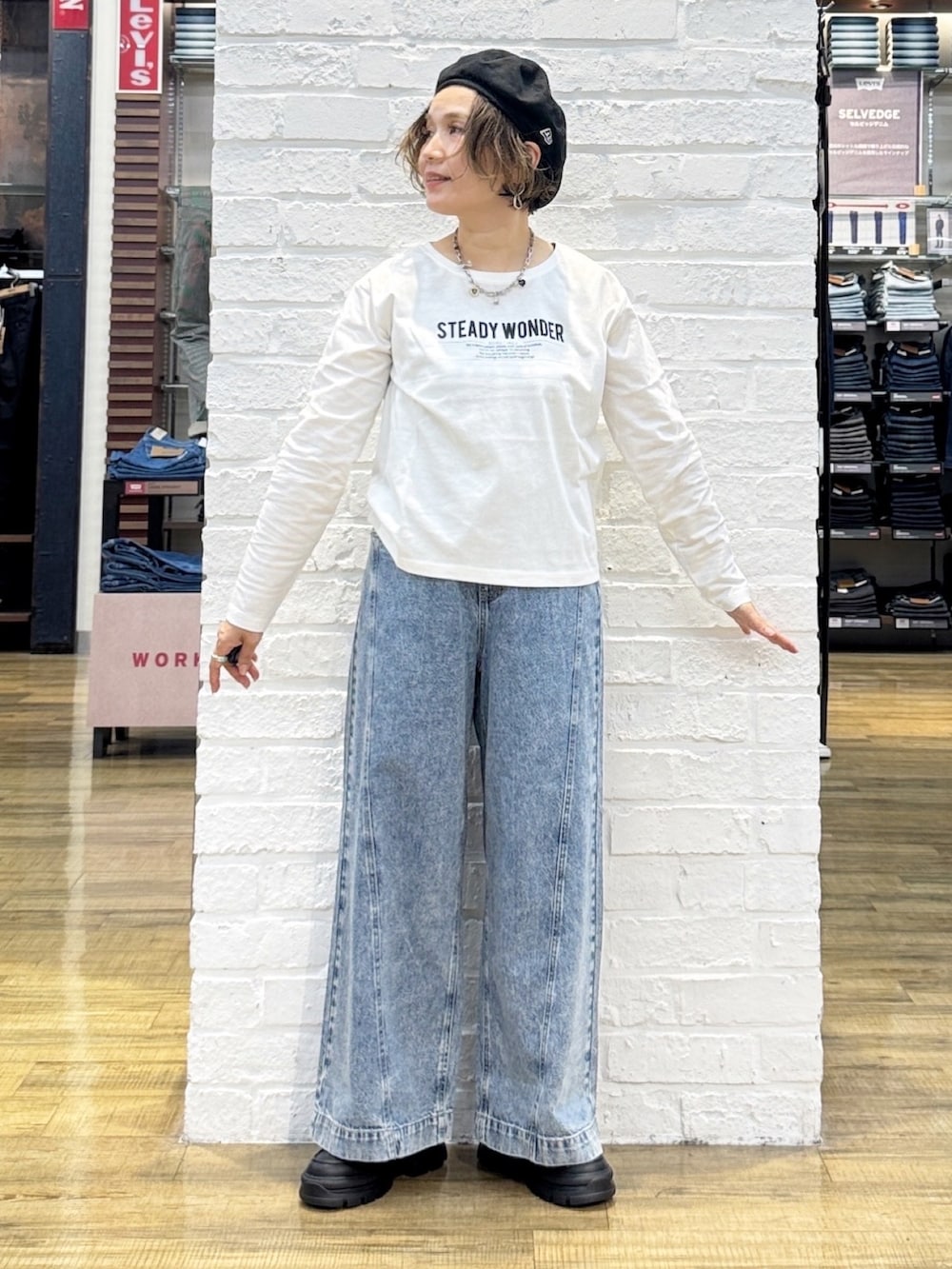 ブラック系のショルダーバッグ、ブラック系のその他シューズ、ブルー系のデニムパンツを着用したレディースの秋コーディネートの5枚目の写真