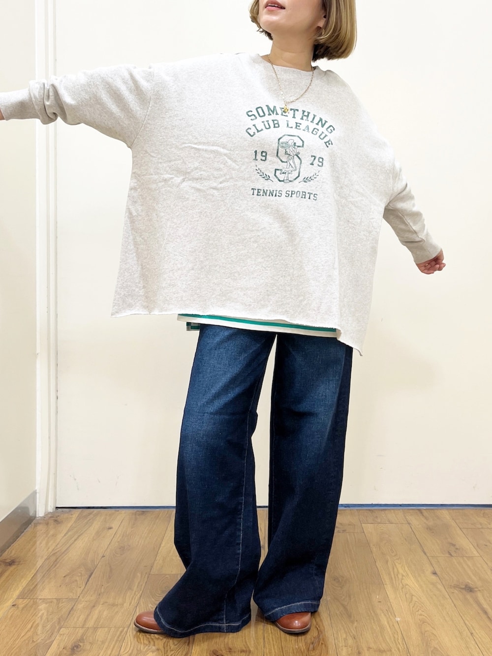 ブルー系のデニムパンツ、グリーン系のTシャツ/カットソー、グレー系のスウェットを着用したレディースの秋コーディネートの3枚目の写真