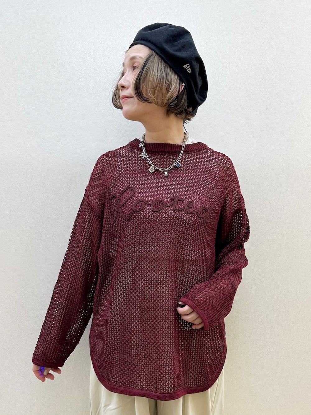 レッド系のニット/セーター、グレー系のその他パンツ、ブラック系のショルダーバッグを着用したレディースの秋コーディネートの2枚目の写真