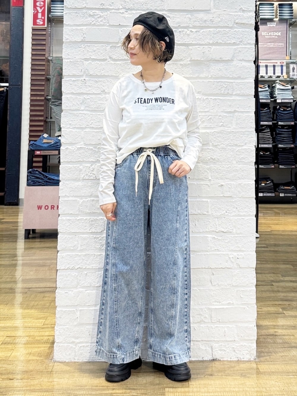 ブラック系のショルダーバッグ、ブラック系のその他シューズ、ブルー系のデニムパンツを着用したレディースの秋コーディネートの6枚目の写真