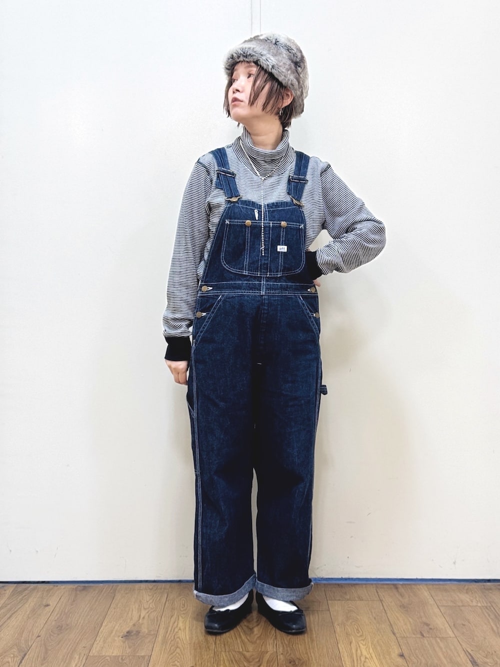 ブルー系のサロペット/オーバーオール、ブラック系のダウンジャケット/コート、レッド系のニット/セーターを着用したレディースの冬コーディネートの9枚目の写真