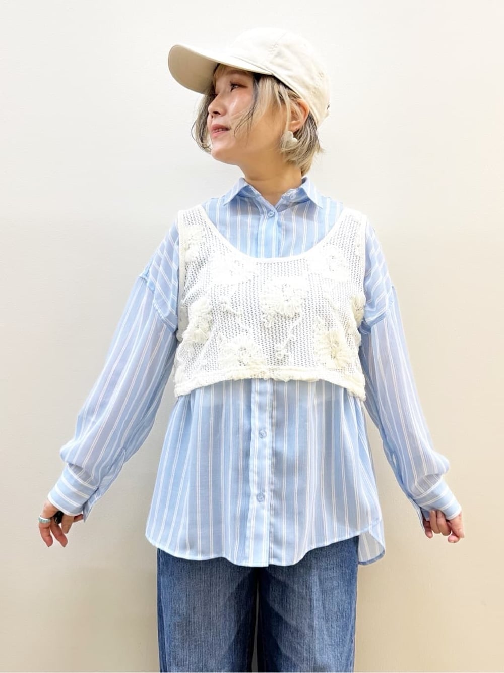 ブルー系のシャツ/ブラウス、ホワイト系のベスト、ブルー系のデニムパンツを着用したレディースの春コーディネートの2枚目の写真