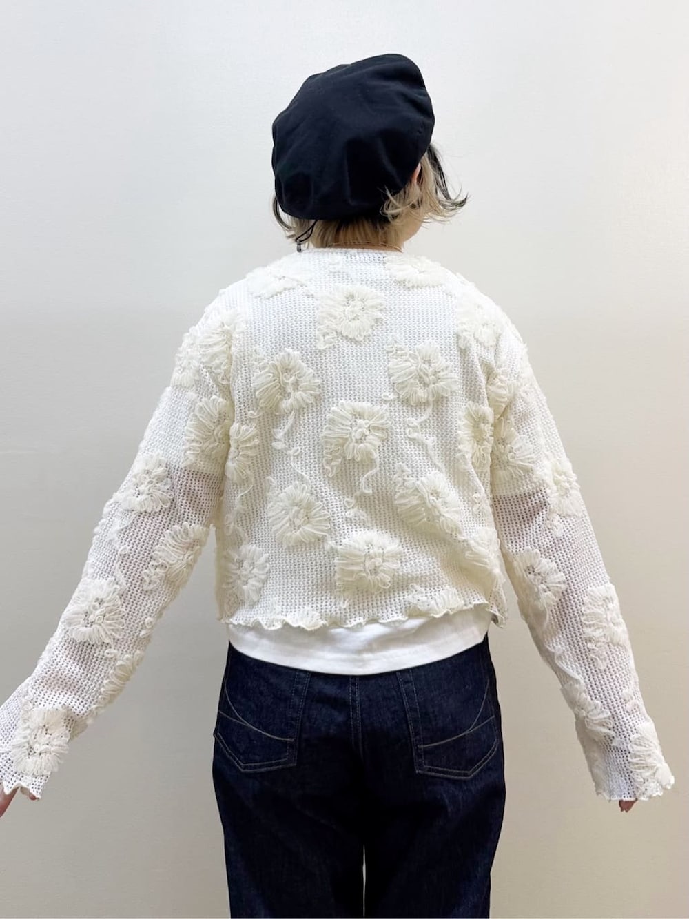 ホワイト系のカーディガン/ボレロ、ホワイト系のTシャツ/カットソー、ブルー系のデニムパンツを着用したレディースの春コーディネートの6枚目の写真