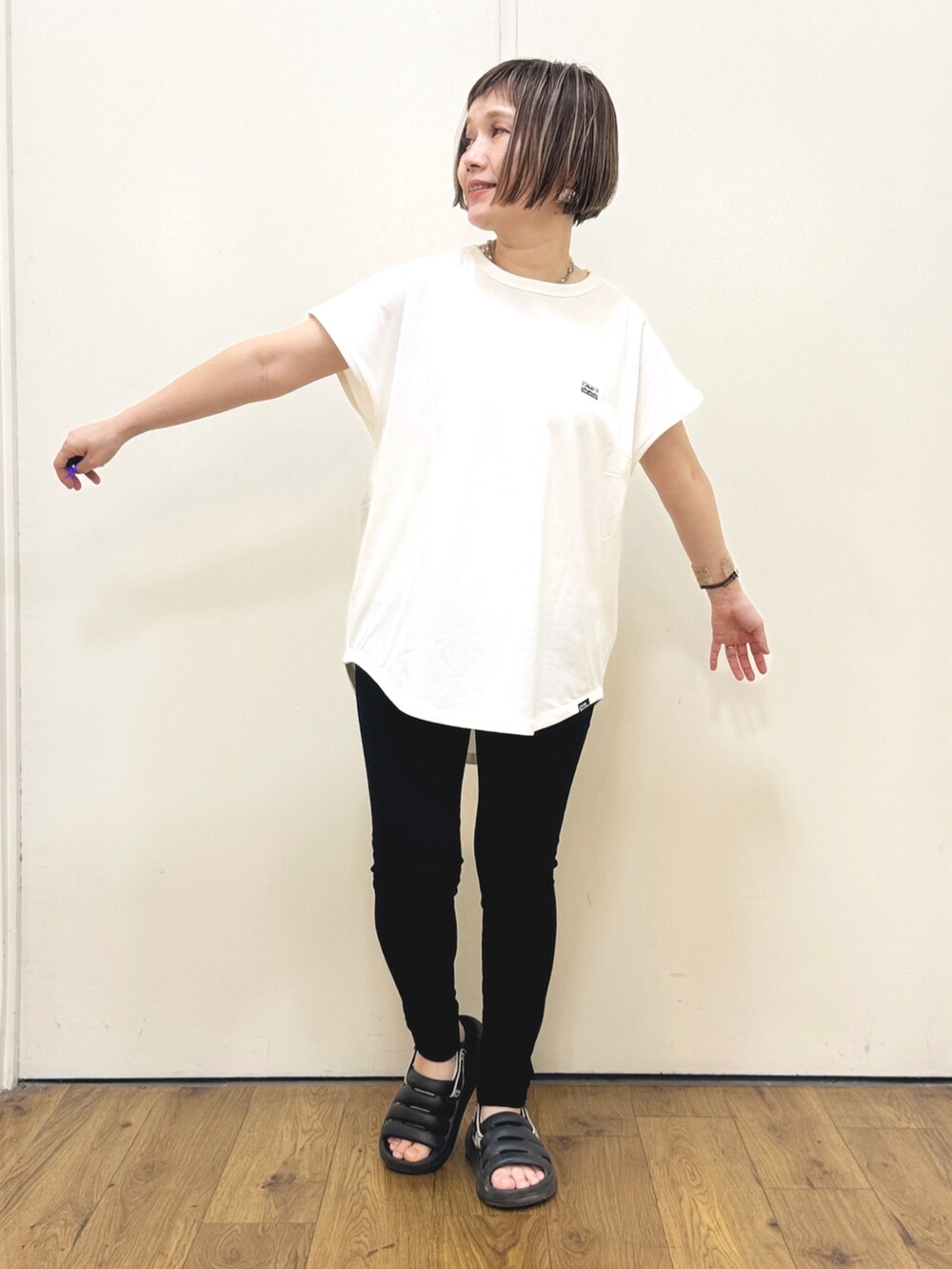 ホワイト系のTシャツ/カットソー、ブラック系のその他パンツ、ブラック系のサンダルを着用したレディースの春コーディネートの3枚目の写真