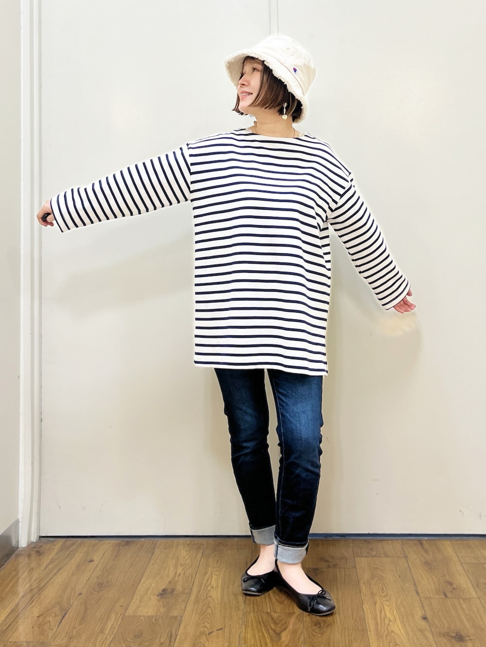 オレンジ系のTシャツ/カットソー、ブルー系のTシャツ/カットソー、ブルー系のデニムパンツを着用したレディースの冬コーディネートの4枚目の写真