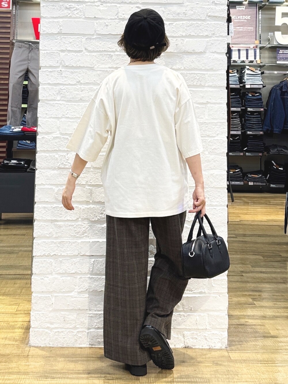 ホワイト系のTシャツ/カットソー、オレンジ系のシャツ/ブラウス、ブラック系のショルダーバッグを着用したレディースの秋コーディネートの8枚目の写真