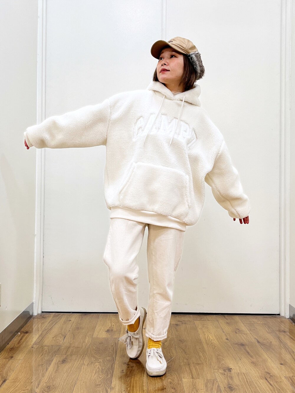 ホワイト系のパーカー、ホワイト系のデニムパンツ、ホワイト系のモカシン/デッキシューズを着用したレディースの冬コーディネートの2枚目の写真
