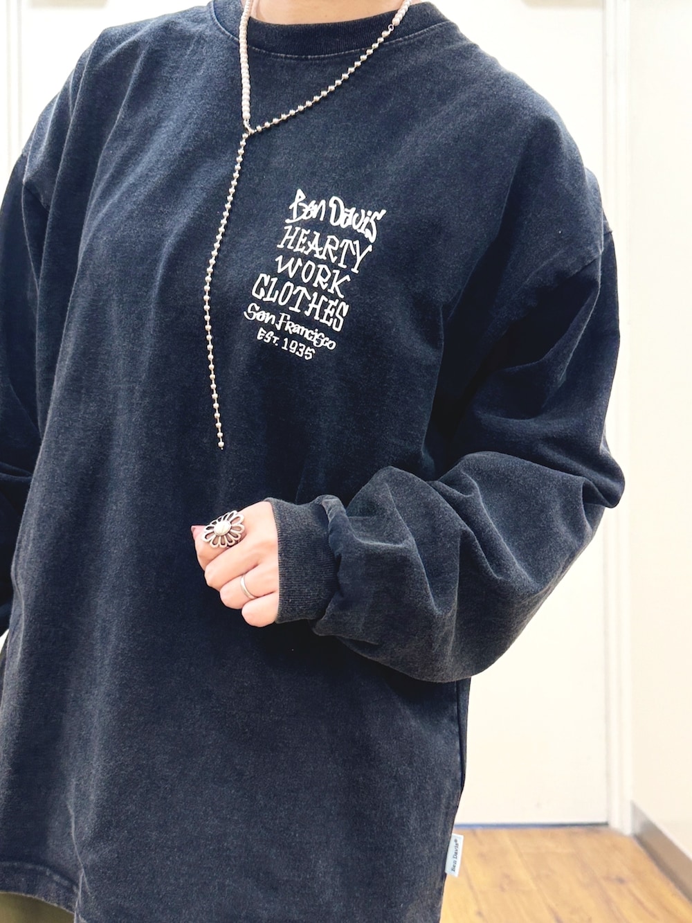 ブラック系のTシャツ/カットソー、ブラック系のバックパック/リュック、ホワイト系のスニーカーを着用したレディースの秋コーディネートの4枚目の写真