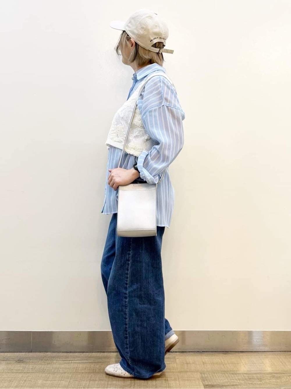 ブルー系のシャツ/ブラウス、ホワイト系のベスト、ブルー系のデニムパンツを着用したレディースの春コーディネートの3枚目の写真