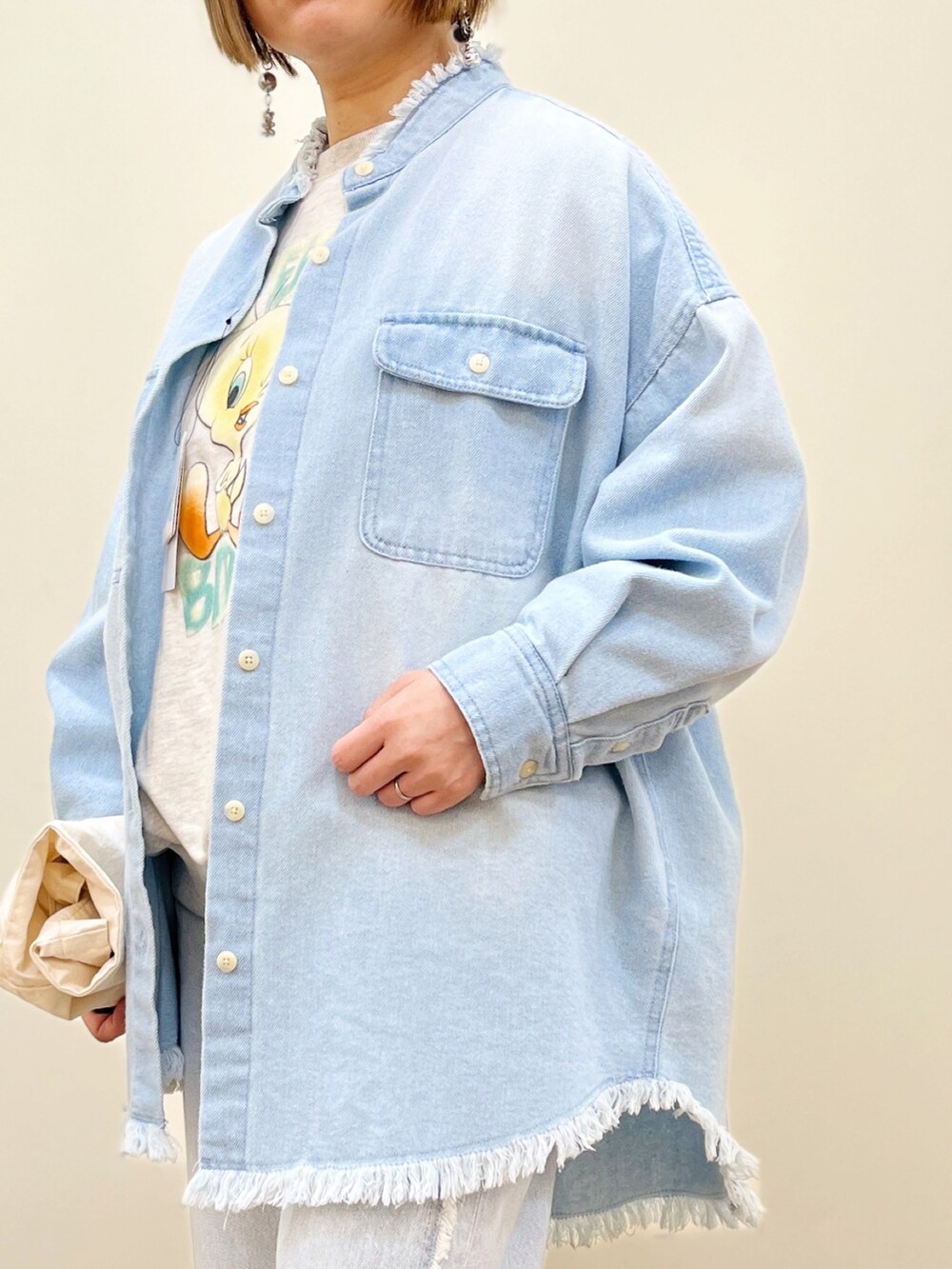 グレー系のスウェット、ブルー系のシャツ/ブラウス、ブルー系のデニムパンツを着用したレディースの春コーディネートの2枚目の写真