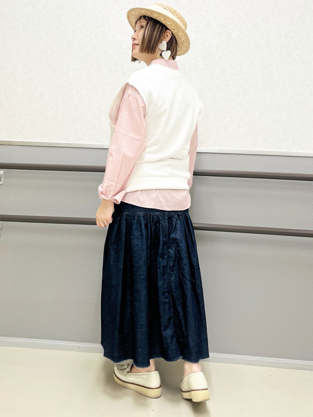 オレンジ系のシャツ/ブラウス、ブルー系のデニムスカート、ブラック系のショルダーバッグを着用したレディースの春コーディネートの2枚目の写真