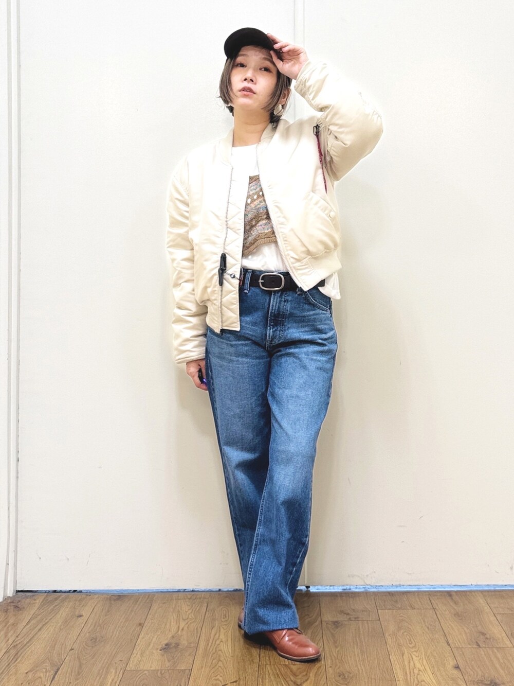 ホワイト系のMA-1、ブルー系のデニムパンツ、ブラウン系のアンサンブルを着用したレディースの秋コーディネートの2枚目の写真