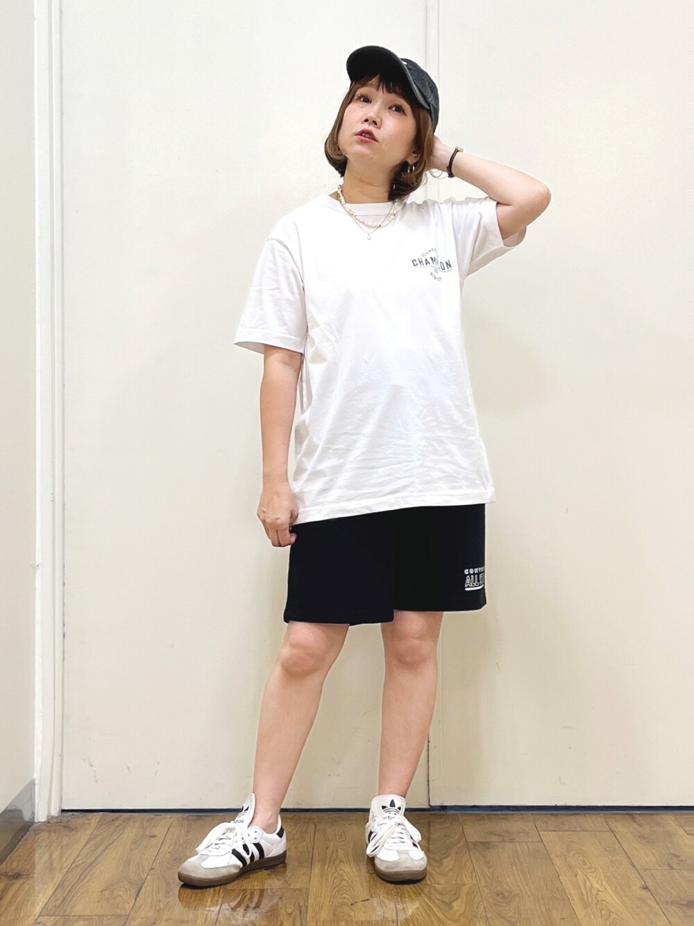 ブラック系のスウェットパンツ、オレンジ系のトートバッグ、ホワイト系のTシャツ/カットソーを着用したレディースの夏コーディネートの3枚目の写真